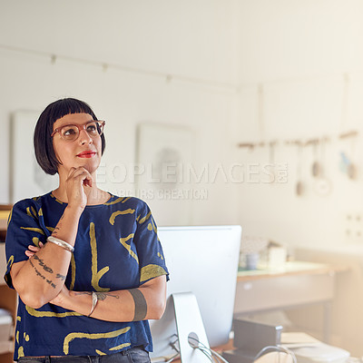 Buy stock photo Shot of a stylish young designer standing in her studio deep in thought