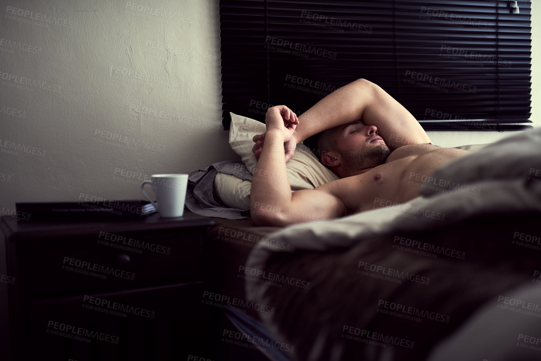 Buy stock photo Shot of a shirtless young man sleeping in his bed