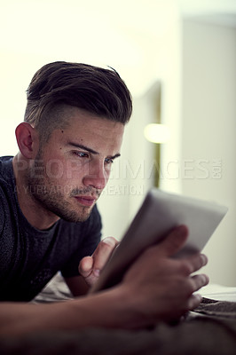 Buy stock photo Internet, tablet and man on bed in house for watching online video with streaming movie and web browsing. Technology, relax and guy on mattress with website for learning language and social media app