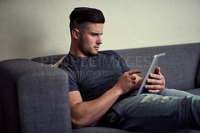 Buy stock photo Man, tablet and social media on weekend sofa, streaming and app subscription for games or movies. Male person, scroll and choice of series on website, online and internet for communication in home