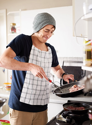 Buy stock photo Cropped shot of a young man cooking at home