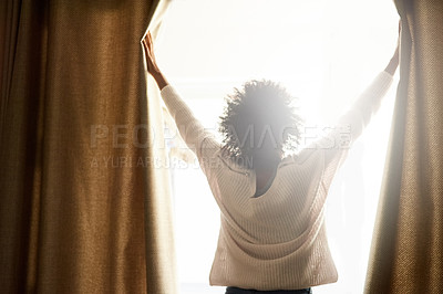 Buy stock photo Rearview shot of a woman opening the curtains on a bright sunny day