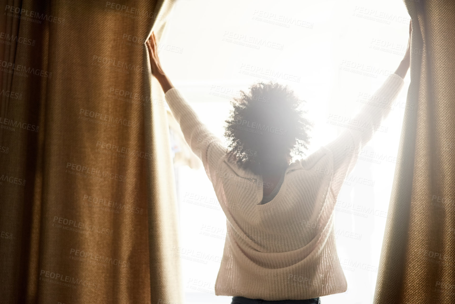 Buy stock photo Rearview shot of a woman opening the curtains on a bright sunny day