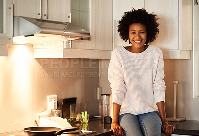 Buy stock photo Portrait of a happy young woman sitting on her kitchen counter
