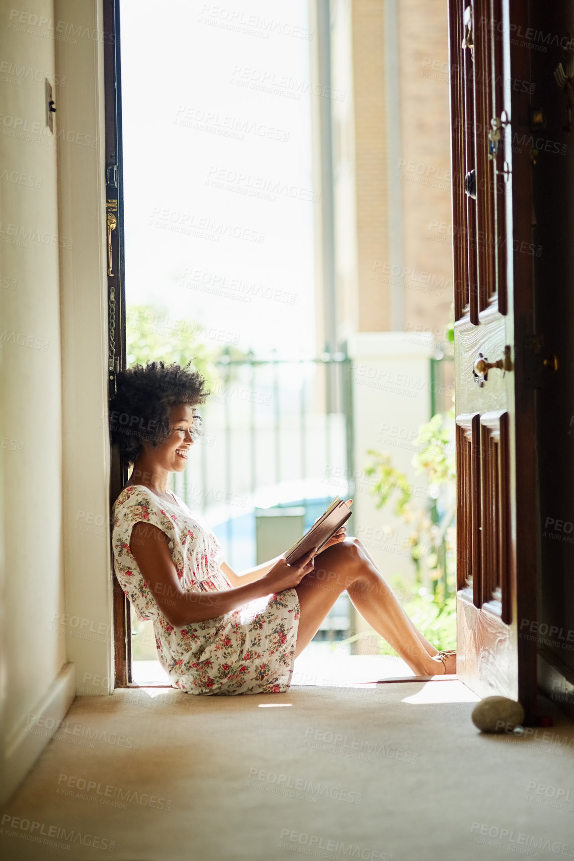 Buy stock photo Black girl, happy and reading as hobby, relax and peace for learning, fun or leisure in home on floor with novel. African woman, entertainment and scholarship in literature for story, poetry or book