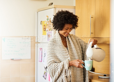 Buy stock photo Shot of a young woman making a cup of tea at home in the morning