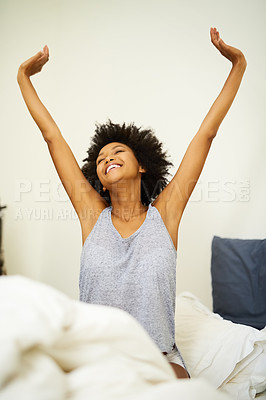 Buy stock photo Shot of a young woman stretching after waking up in her bed