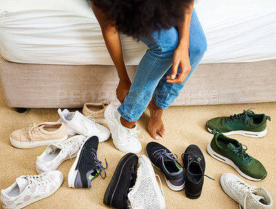 Buy stock photo Cropped shot of a woman trying on different pairs of shoes