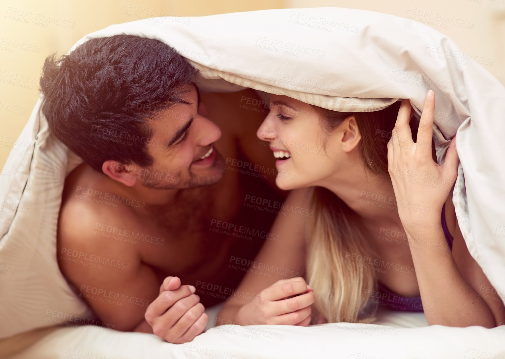 Buy stock photo Couple, bed and cover with blanket, laugh and happy with memory, conversation or joke in morning. Man, woman and wake up with smile for joke, playful and funny story in bedroom together in apartment