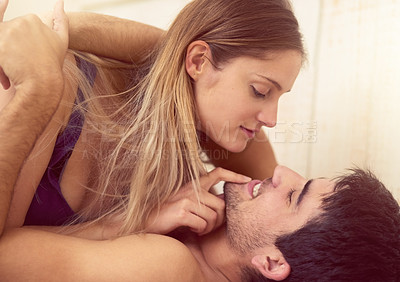 Buy stock photo Shot of a loving young couple getting intimate in bed
