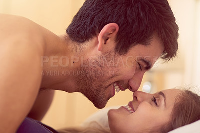 Buy stock photo Shot of a loving young couple getting intimate in bed