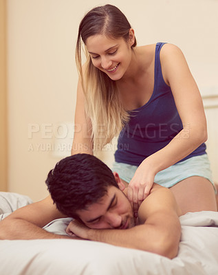 Buy stock photo Shot of a happy young woman giving her boyfriend a back massage in bed