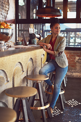 Buy stock photo Shot of a young woman working on a laptop in a cafe