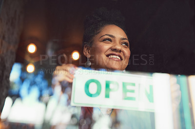 Buy stock photo Cropped shot of a young woman hanging up an 