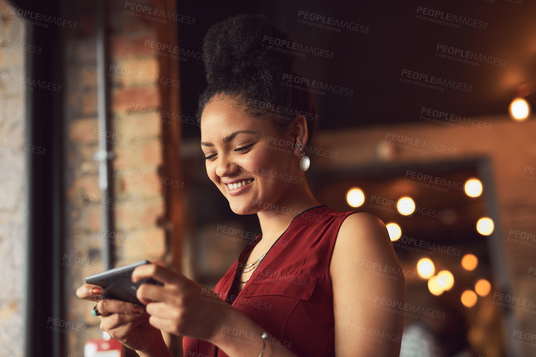 Buy stock photo Cropped shot of a young woman texting on a cellphone in a cafe