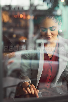 Buy stock photo Cropped shot of a young businesswoman using a digital tablet in a cafe