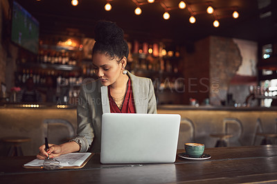 Buy stock photo Cropped shot of a young businesswoman working on her laptop in a cafe