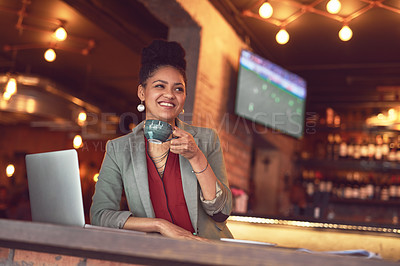 Buy stock photo Cropped shot of a young businesswoman enjoying a cup of coffee while working on her laptop in a cafe
