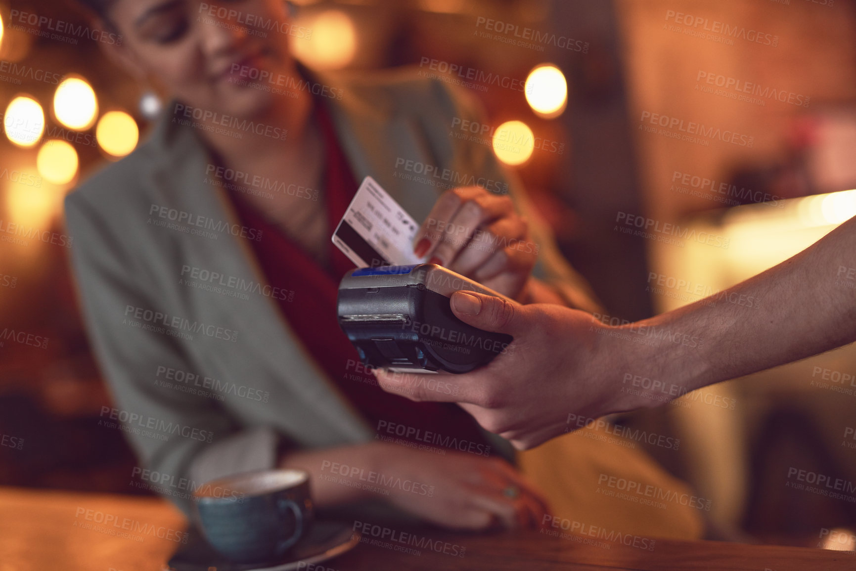 Buy stock photo Closeup shot of a young woman swiping her credit card to make a payment in a cafe