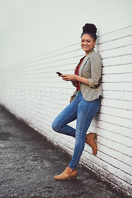 Buy stock photo Portrait of a beautiful young woman standing against a brick wall