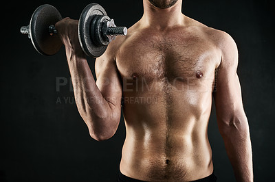 Buy stock photo Studio shot of a man's torso while lifting weights against a dark background