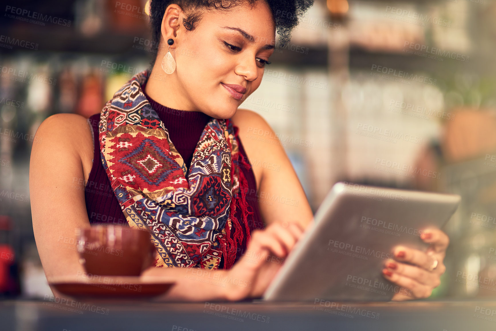 Buy stock photo Cropped shot of an attractive young woman using a digital tablet in a cafe