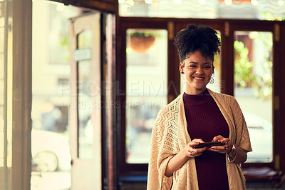 Buy stock photo Portrait of an attractive young woman texting on her cellphone in a cafe