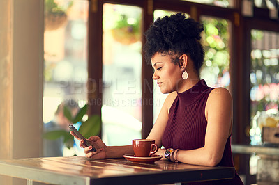 Buy stock photo Cropped shot of an attractive young woman texting on her cellphone in a cafe