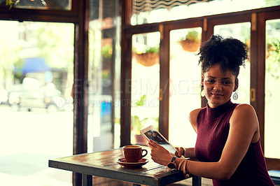 Buy stock photo Portrait of an attractive young woman using a digital tablet in a cafe