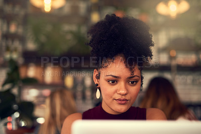 Buy stock photo Cropped shot of a young woman working on her laptop in a cafe