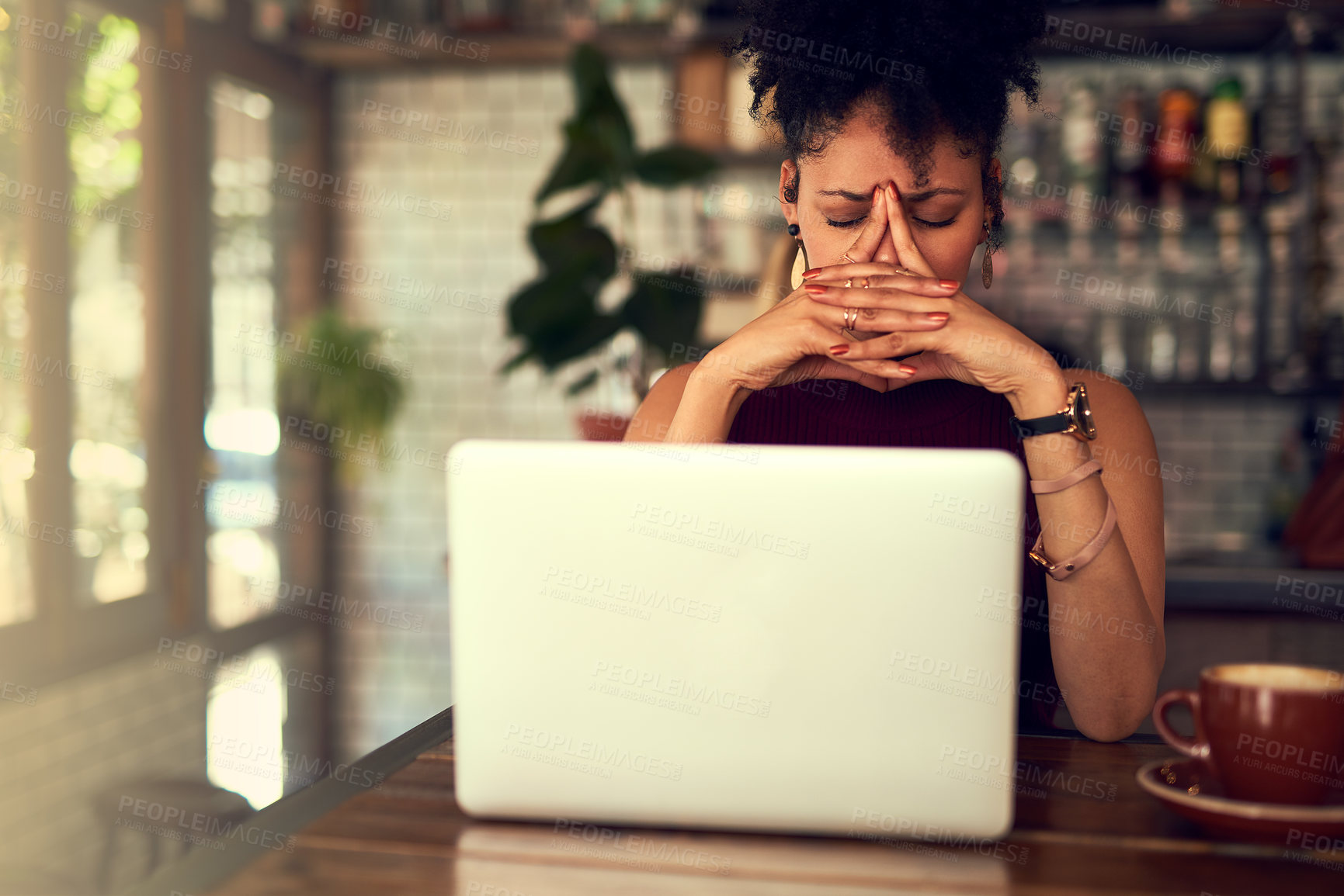 Buy stock photo Cropped shot of a young woman looking stressed out while working on her laptop in a cafe