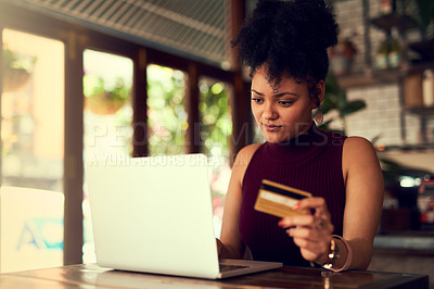 Buy stock photo Cropped shot of a young woman using a credit card to make an online payment