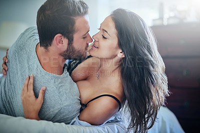 Buy stock photo Shot of an affectionate couple lying on their bed