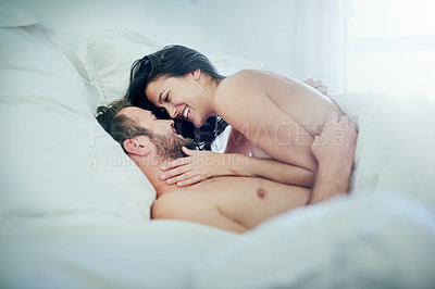 Buy stock photo Shot of a young couple sharing an intimate moment in their bedroom