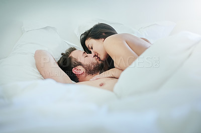 Buy stock photo Shot of an affectionate couple lying on their bed