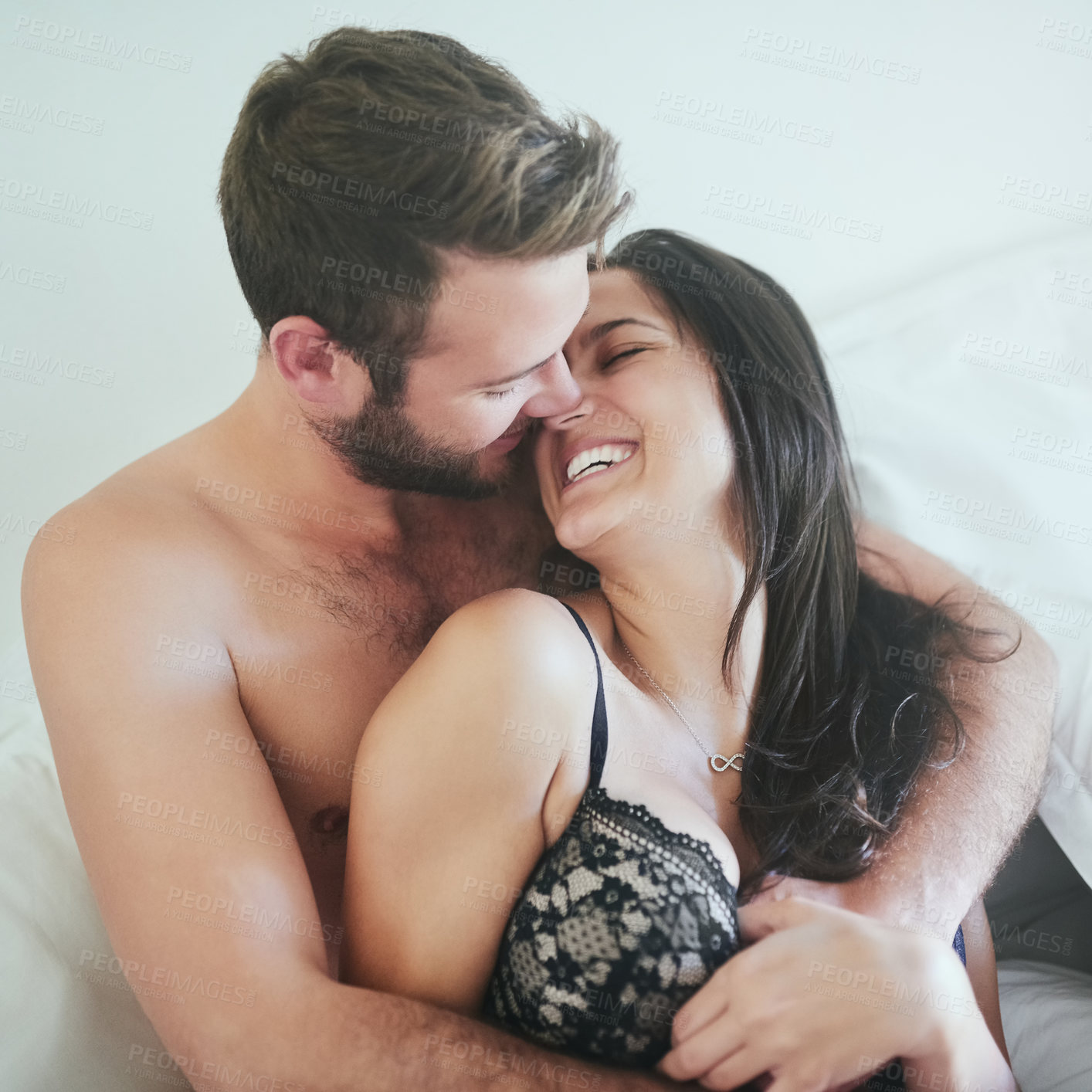 Buy stock photo Love, morning and couple in bed with smile, romance and happy bonding in apartment. Relationship, man and woman relax in bedroom with intimate embrace, kiss and wake up with care on weekend in home