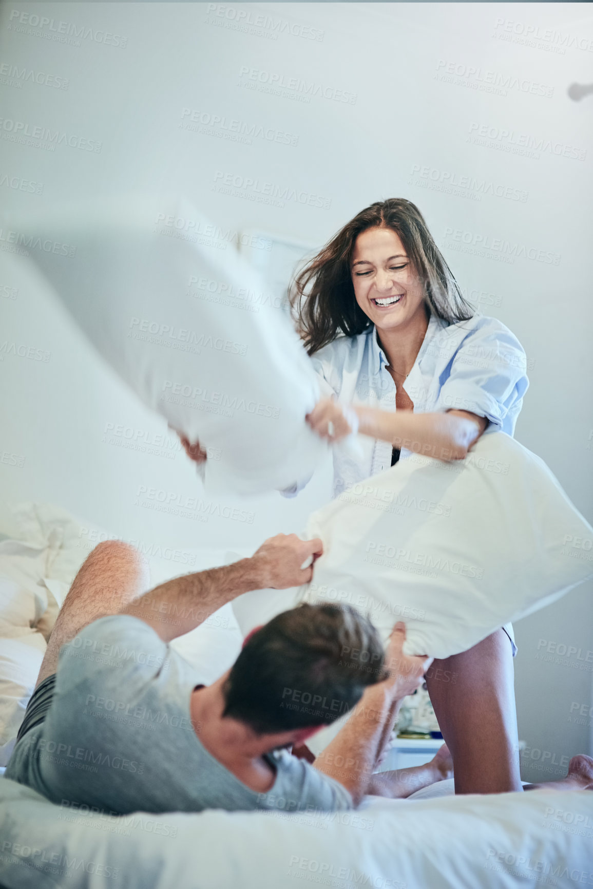 Buy stock photo Couple, pillows and laughing in bedroom for fight, together and fun in relationship for love. People, cushion and game in home for bonding, comedy and energy for crazy morning date for marriage