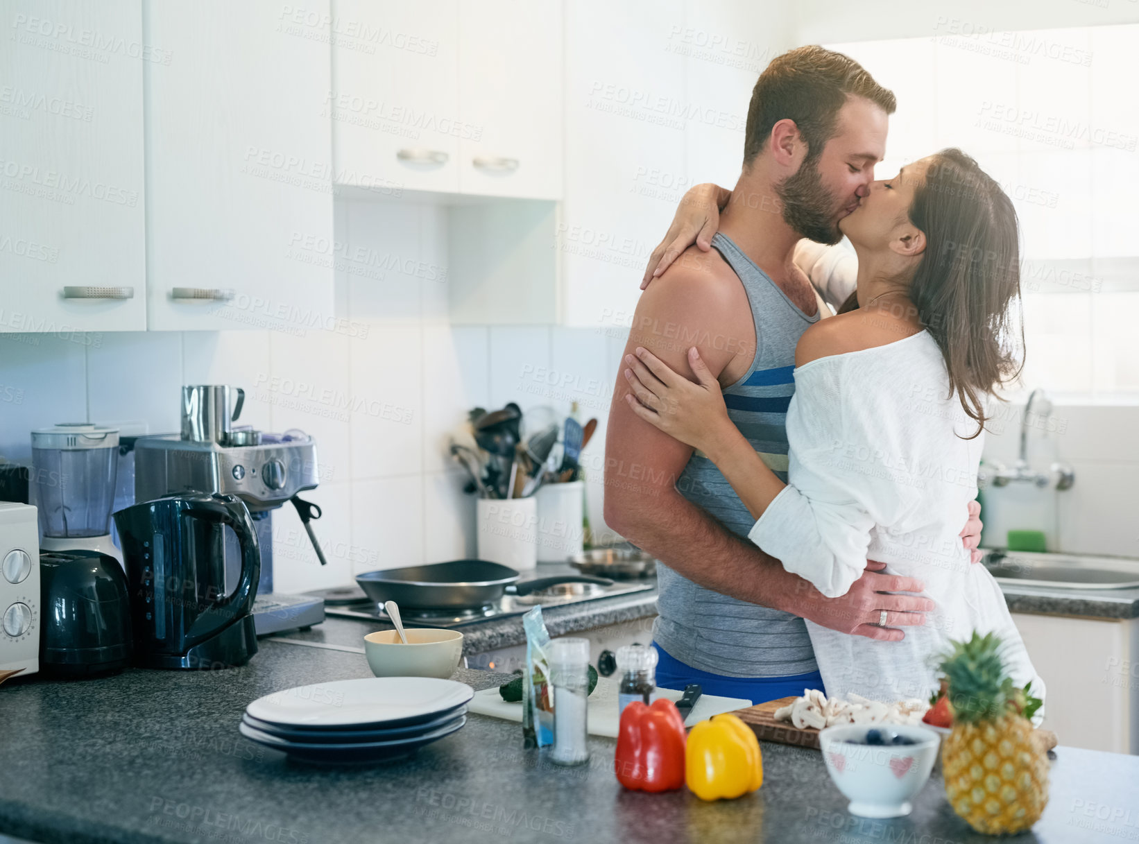 Buy stock photo Cooking, kiss and couple in kitchen with food for meal prep for dinner, supper and lunch in home. Relationship, dating and man and woman embrace with healthy ingredients for bonding, love and romance