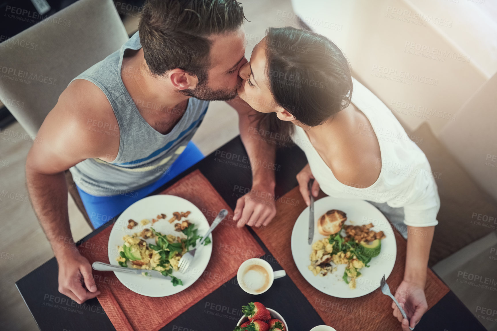 Buy stock photo Love, romance and couple with breakfast, kiss and happy morning together in hotel room for honeymoon date. Passion, bonding and man at table with woman, healthy food and coffee at home from above