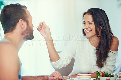 Buy stock photo Breakfast, home and couple feeding with health food, happy and love with marriage at table. Hungry, eating and woman with fruit and cooking in new house with anniversary, romance and care with smile