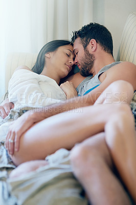 Buy stock photo Shot of a young couple enjoying a romantic moment on the sofa together in the morning