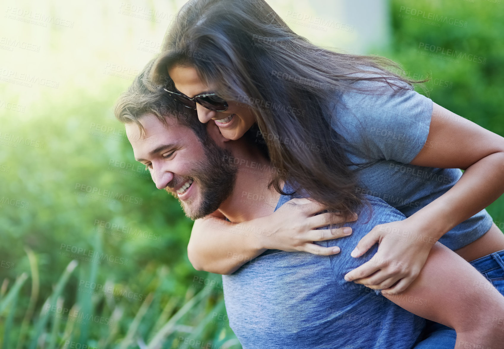 Buy stock photo Couple, piggy back and happy at park in summer with nature, holiday or playful adventure with love. Man, woman and excited with comic game, memory and laugh together on walk with sunshine in garden