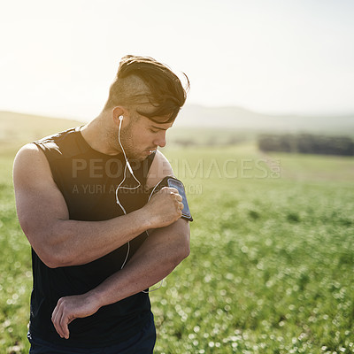 Buy stock photo Runner, exercise and man in nature with armband for strong body, streaming music playlist and training for marathon. Outdoor, earphones and male athlete with health for discipline and listen to audio