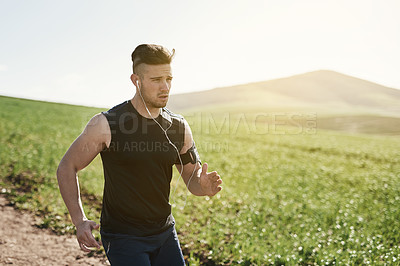 Buy stock photo Nature, running and man with earphones for music, physical exercise and training for sports competition with health. Outdoor, listen to sound and male runner for workout with online audio playlist