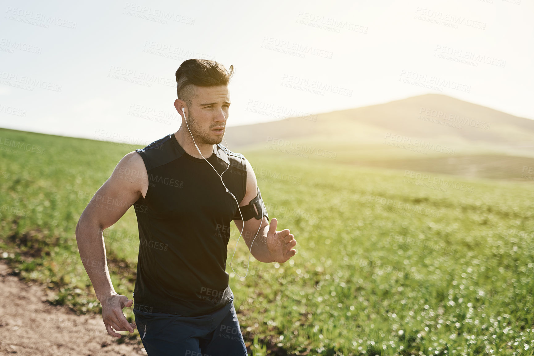 Buy stock photo Nature, running and man with earphones for music, physical exercise and training for sports competition with health. Outdoor, listen to sound and male runner for workout with online audio playlist