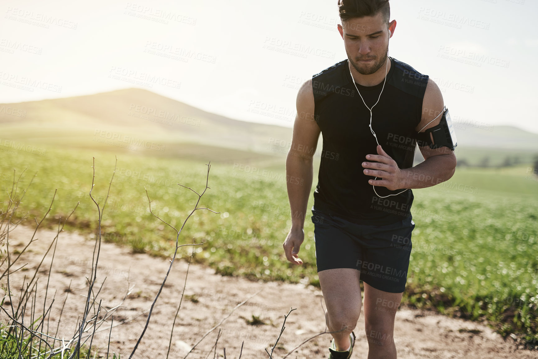 Buy stock photo Man, earphones and music for running in outdoor, marathon training and health in countryside. Male person, streaming and audio for motivation in nature, fitness and radio for cardio or listen to song