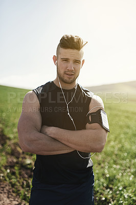 Buy stock photo Cropped portrait of a sporty young man standing outside with his arms folded