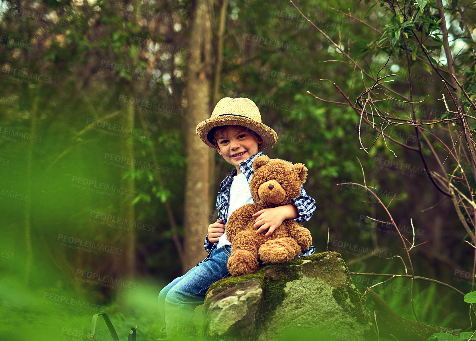 Buy stock photo Happy, young boy and teddy bear in forest for adventure with straw hat outdoor in nature. Excited, male kid and stuffed animal in woods with trees for fun, relax and exploration or discovery 