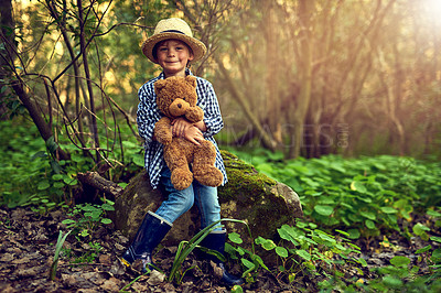 Buy stock photo Happy, young boy and teddy bear in wood for adventure with straw hat and rain boots for exploration in nature. Excited, male kid and stuffed animal in forest with trees for fun, relax and discovery 