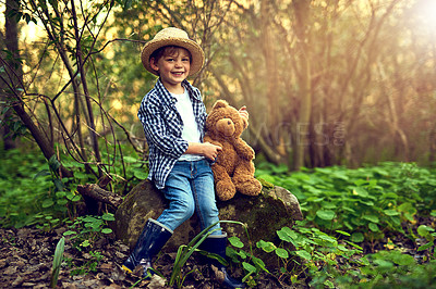 Buy stock photo Shot of a little boy sitting in the forest with his teddy bear